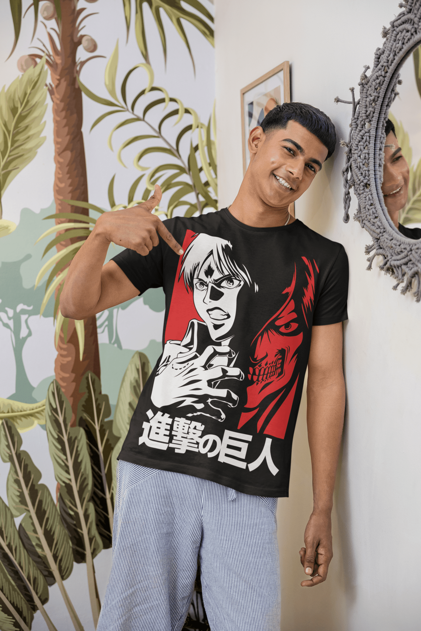 Smiling man points at anime Attack on Titan t-shirt in cozy room with palm wallpaper